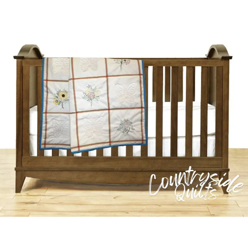 Wooden baby crib adorned with Aunt Martha’s Quilting Fabric in Multi Stripe Print