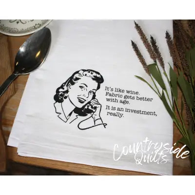 White tea towel with retro illustration reading It’s like wine for Aunt Martha’s Dirty Laundry